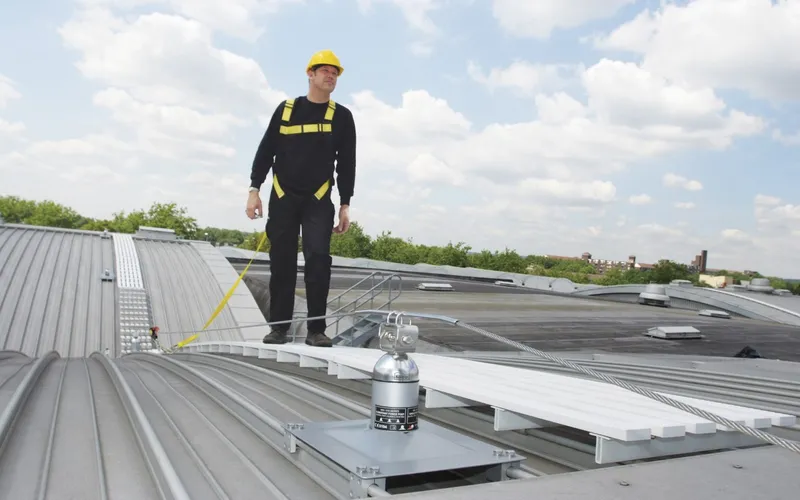Latchways Constant Force post and rooftop walkway with a harnessed operative clipped on