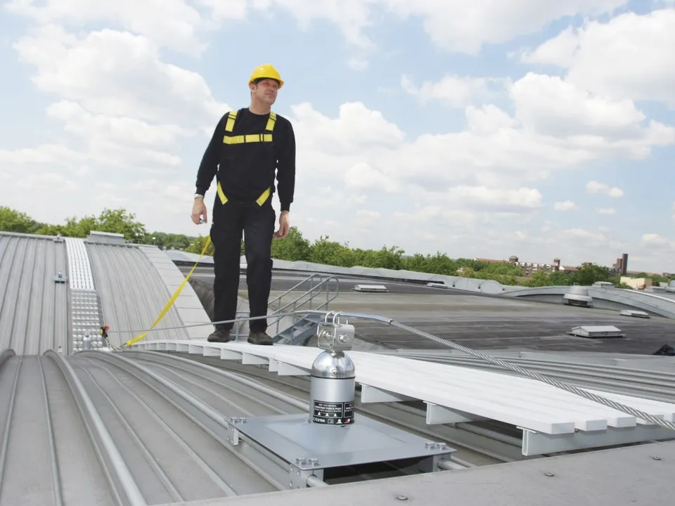 Onestop operative on a rooftop walkway using a Latchways post