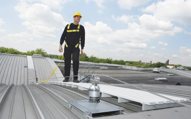 Latchways Constant Force post and rooftop walkway with a harnessed operative clipped on